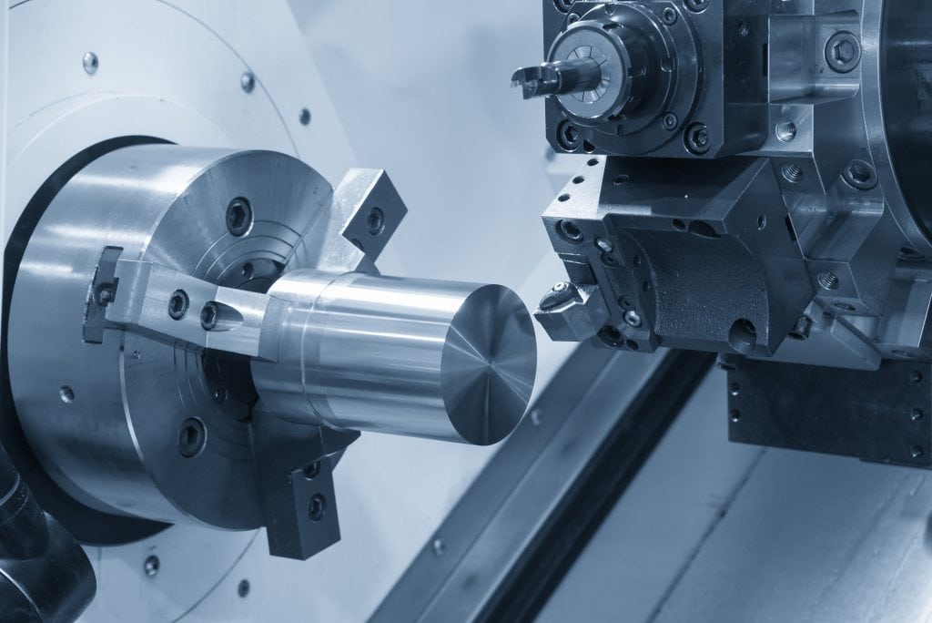 726993544 Close up of a CNC lathe clamping a raw material steel rod