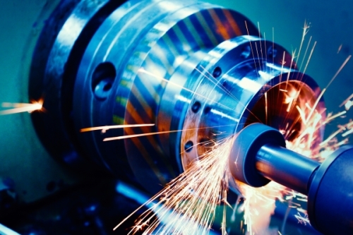 785685547 Close up of chc machining in blue light with sparks flying