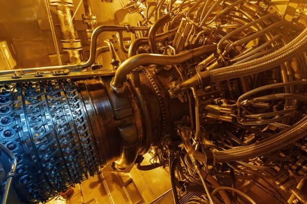precision-machining Gas turbine engine inside pressurized enclosure with a golden light reflecting off the pipes