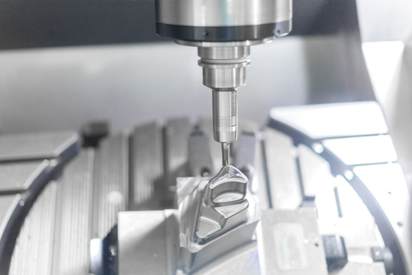 565883593 High precision CNC machining center 5 axis working on an aluminum automotive part