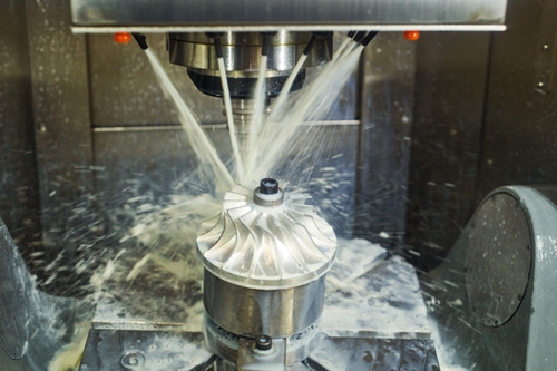 521421988 Industrial CNC milling machine working on a turbine with seven jets of water flowing over the process