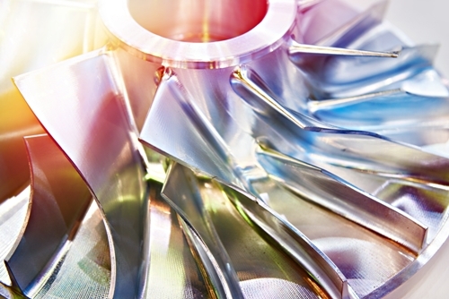 1113593840 Close up view of an aluminum impeller pump with rainbow colored light refracting off the top