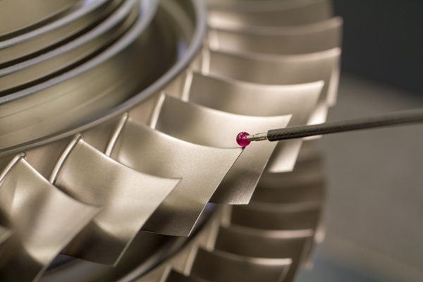 1285171435 Using a rod with a small pink glass bead on the tip to inspect the parts of a turbine